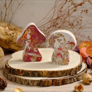 Set of two wooden mushroom block ornaments featuring woodland animals including fox, hedgehog and mice, with red and white backgrounds and foliage details, measuring 9 x 2.5 x 12cm.