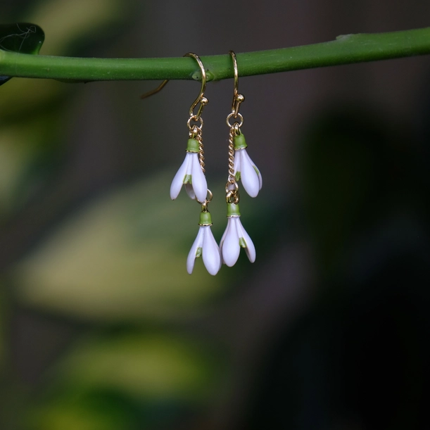 Gold plated snowdrop flower drop hook earrings with white and green enamel floral design, elegant botanical jewellery with hypoallergenic hooks, lightweight drop earrings inspired by nature.