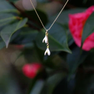 Gold plated snowdrop flower necklace with white and green enamel floral pendant, elegant botanical jewellery design inspired by nature, delicate flower charm with 48.5cm drop length.