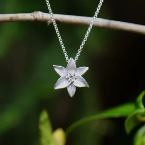 Silver plated white lily pendant necklace with hand enamel white flower design, elegant botanical jewellery on an adjustable chain, ideal for pairing with the matching White Lily Stud Earrings.