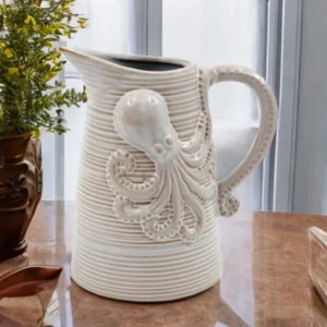Ceramic octopus jug with sculpted tentacles, ribbed texture, neutral glaze, curved handle, and flared spout, styled as coastal nautical home décor.