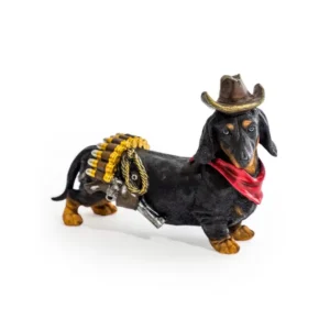 Black and tan Dachshund figurine dressed as a cowboy sheriff with a brown hat, red bandana, holster, and ammunition belt on a white background.