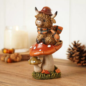 Country Living Highland Cow on Mushroom resin ornament featuring a Highland cow perched on a woodland toadstool, perfect for autumn and rustic home decor.