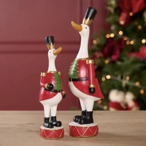 Red and gold Christmas duck figurine standing on a drum with black boots